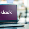 Photograph of laptop displaying logo of Slack